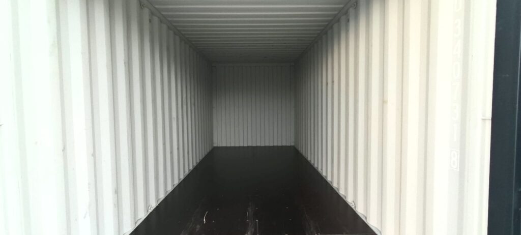 Inside an empty 20ft container at PalmaBox, white walls and a marine plywood floor