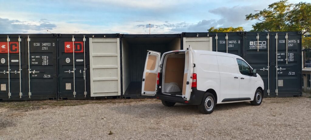 Van parked at an open container door at PalmaBox, loading off the tailgate
